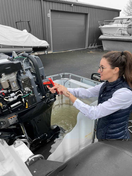 Expert Maritime à Saint-Malo en Ille-et-Vilaine à l'arrière d'un ZODIAC en train de relever la température d'un moteur hors-bord SUZUKI.